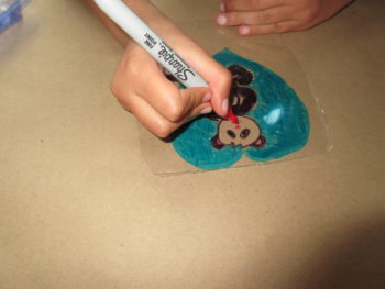 My daughter creating her own shrink art panda pendant.